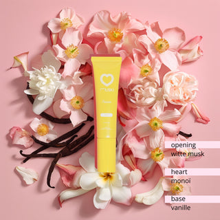 Muski Passion intieme musk tube omringd door tropische bloemen en vanillepeulen.